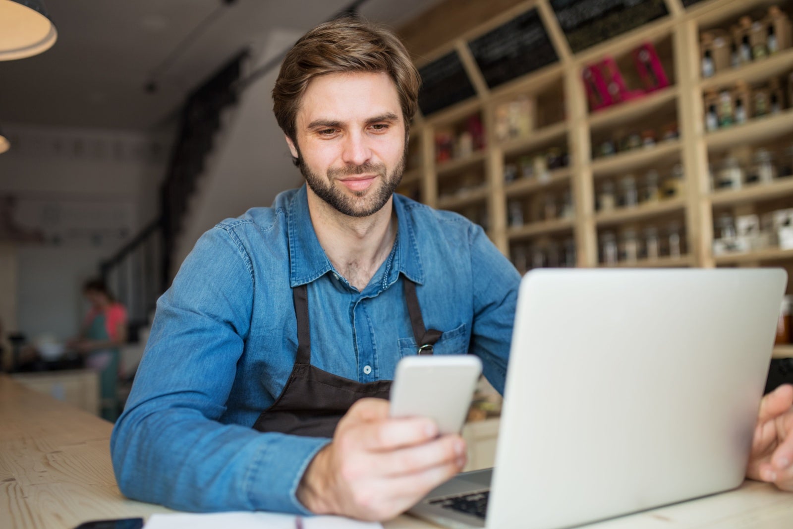 Businessman working on his shop on a laptop and phone