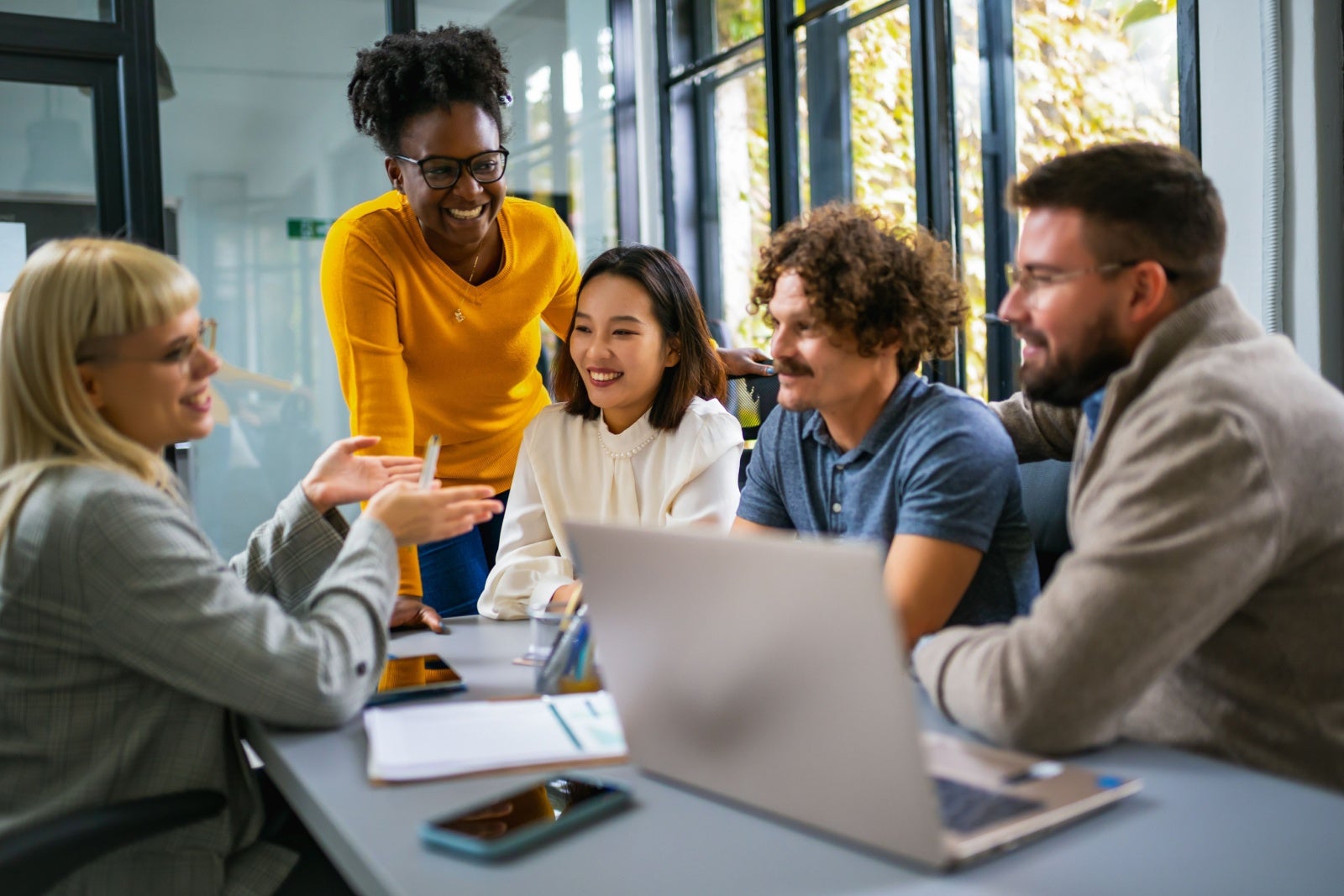 Group of young businesspeople gatherered around a table discussing ideas.