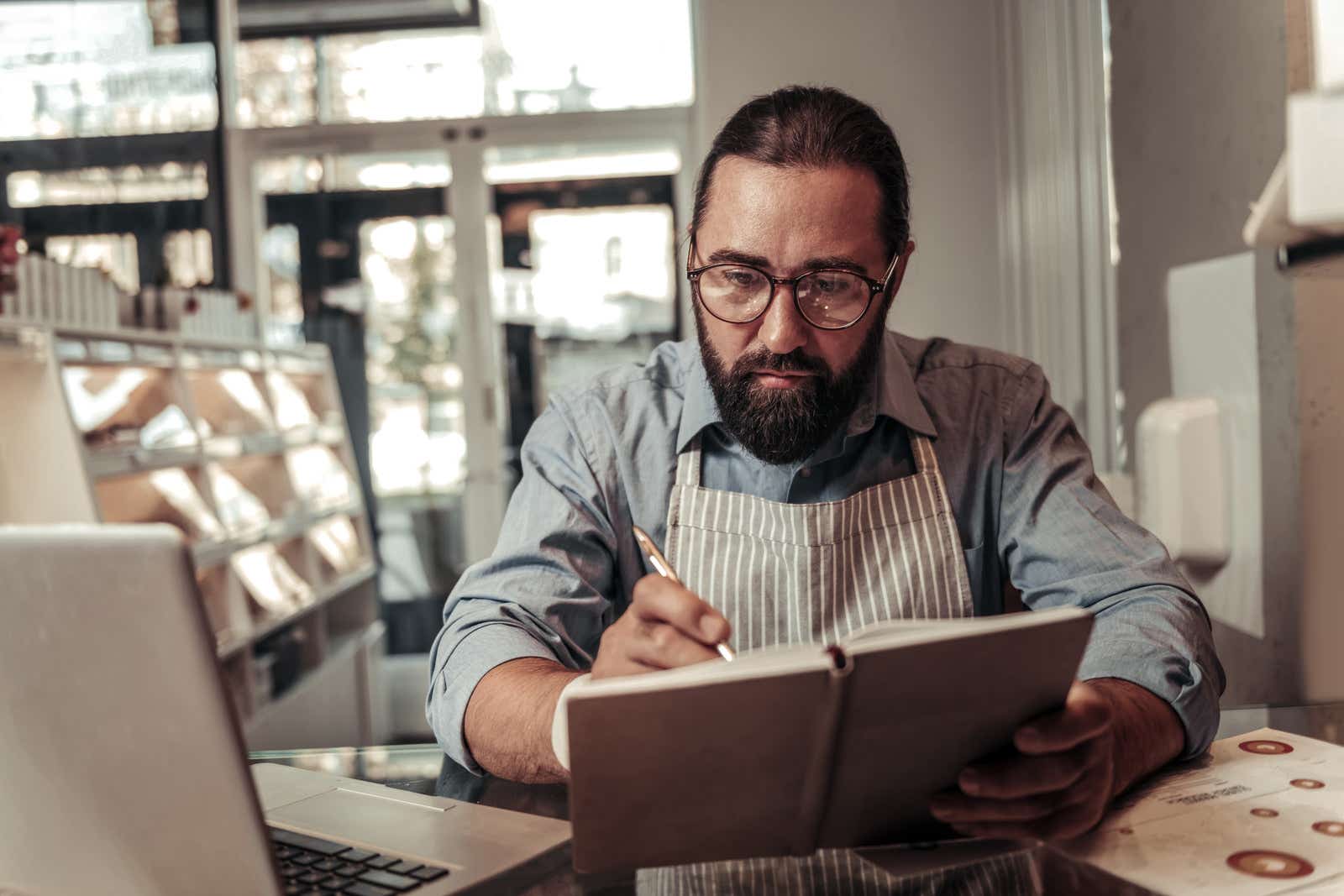 Serious small business owner focusing on his work while checking a business plan