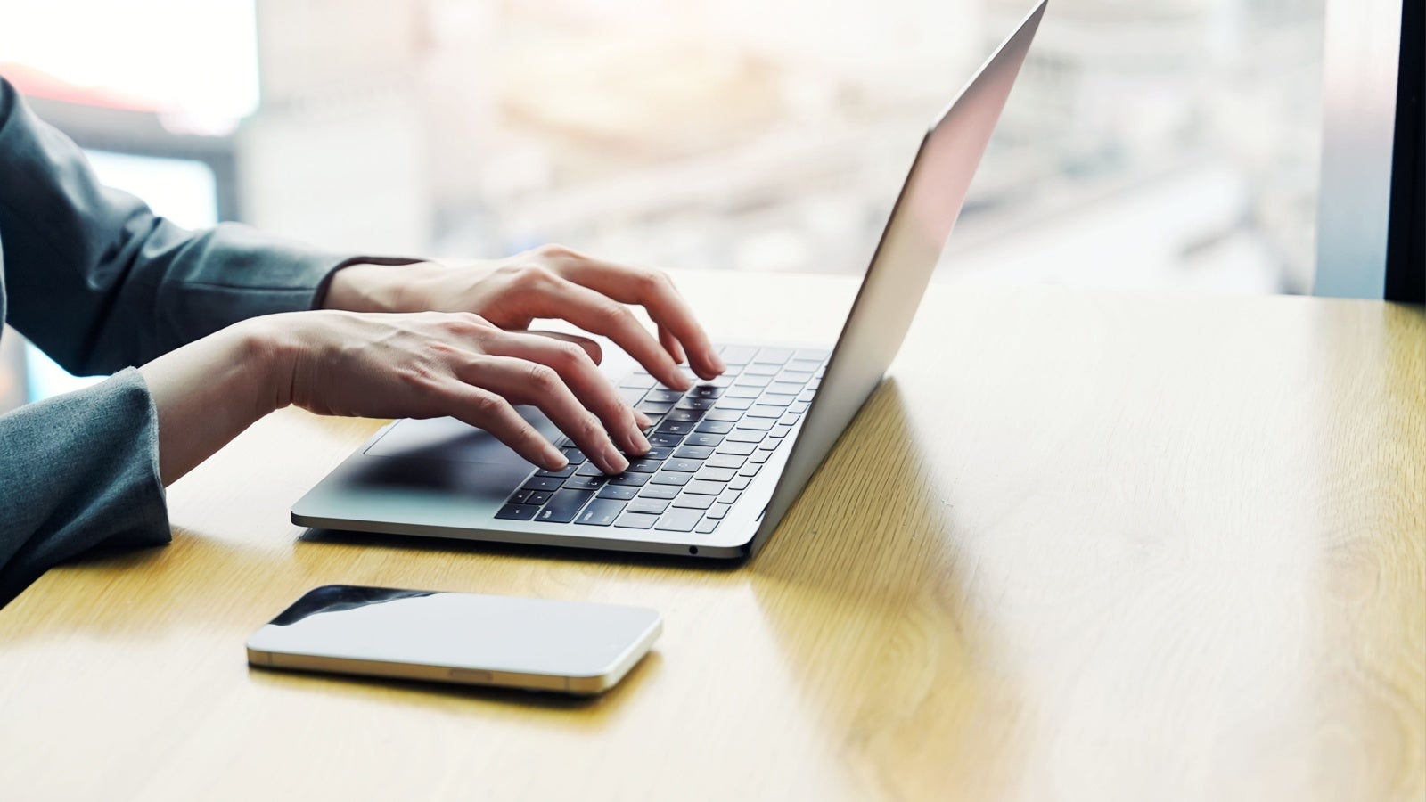 Hands typing on a laptop keyboard