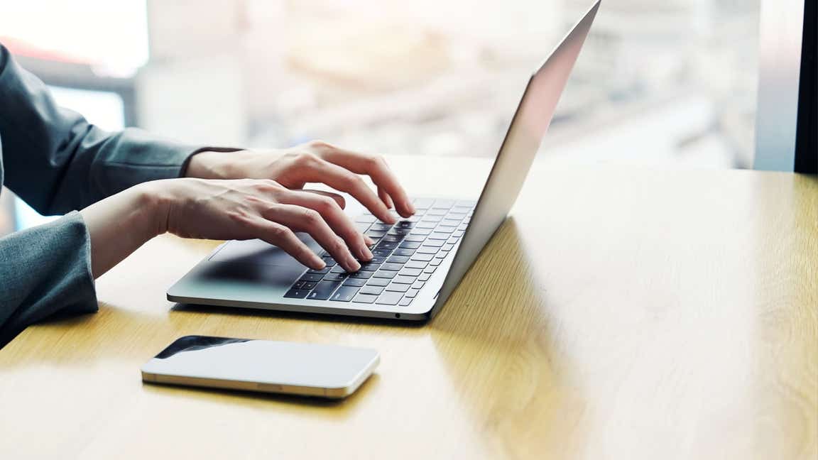 Hands typing on a laptop keyboard