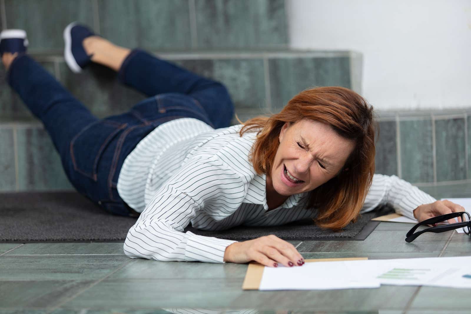 A woman in pain after falling down steps.