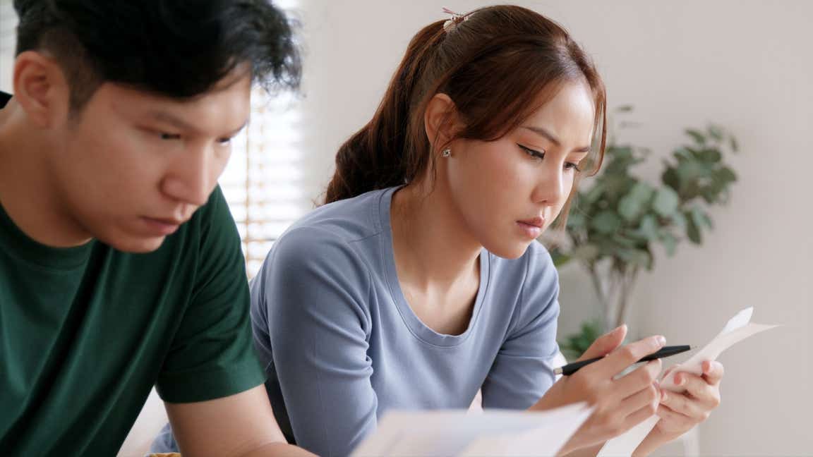 A couple try to calculate their finances.