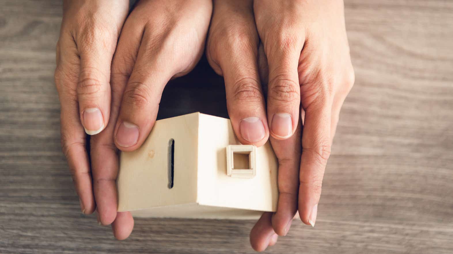 Couple Hands Holding Housing Model