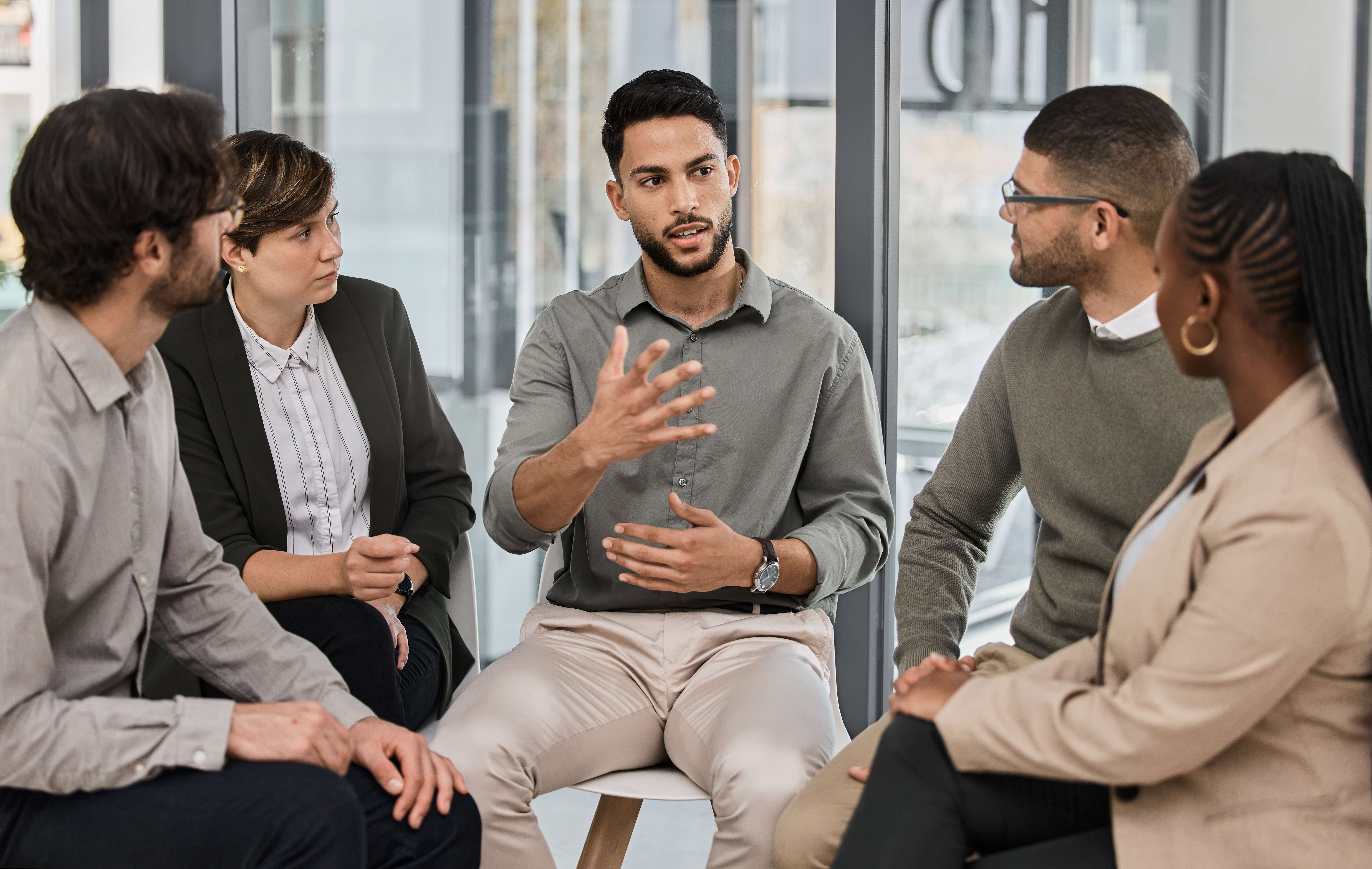 Focus group sit in a semi-circle around a moderator.