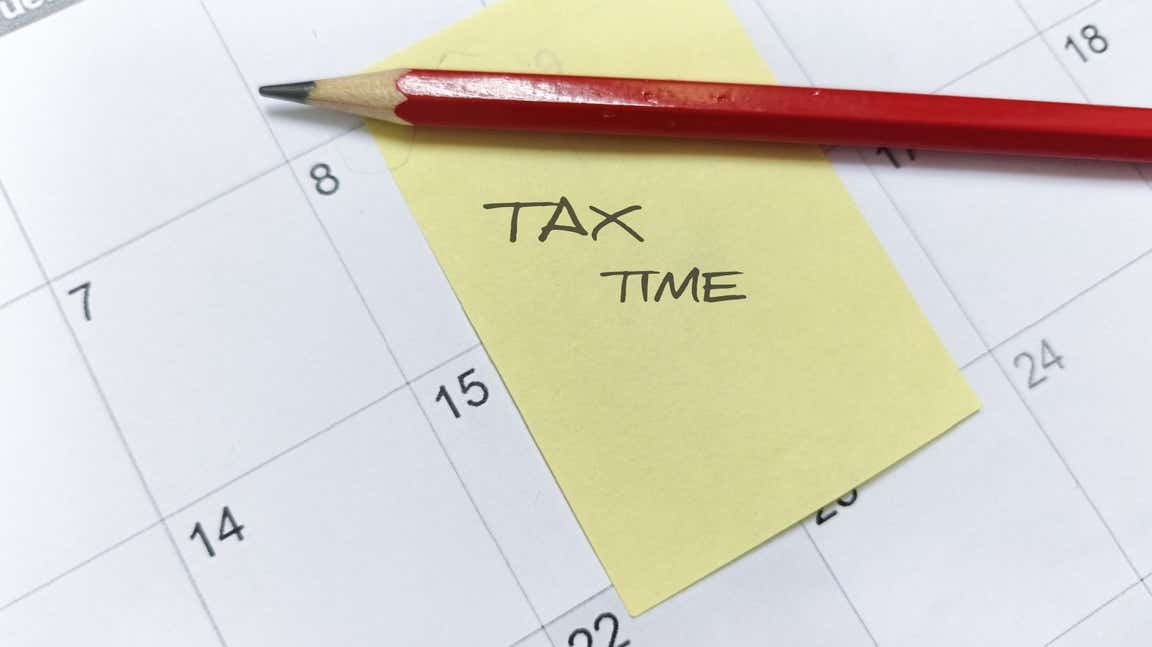 PostIt note with "Tax Time" written on it stuck on a calendar.