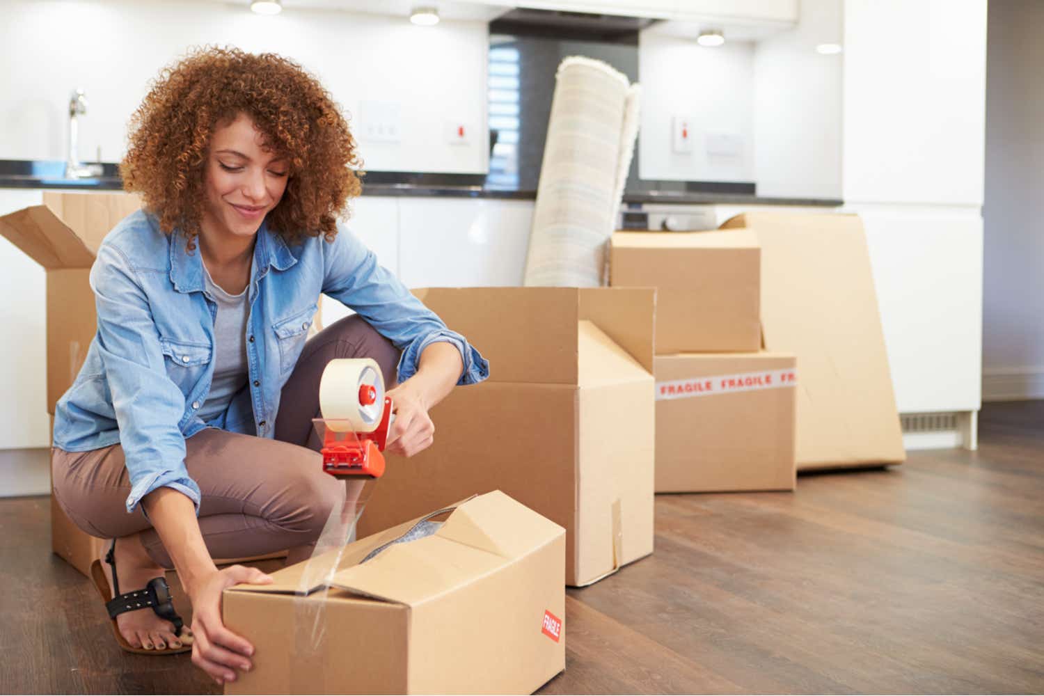 Woman taping boxes during moving house