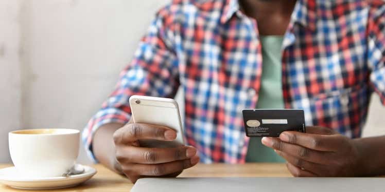 Man holding a credit card and a phone