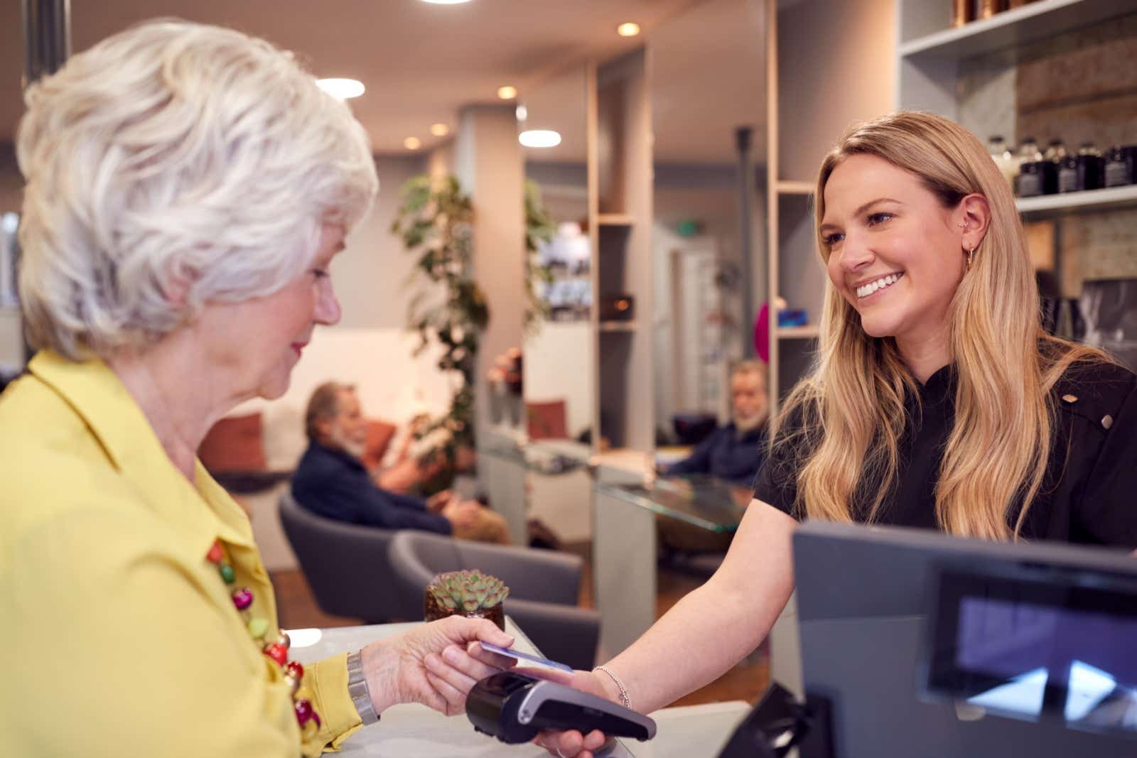 Hairdresser takes payment from her customer.