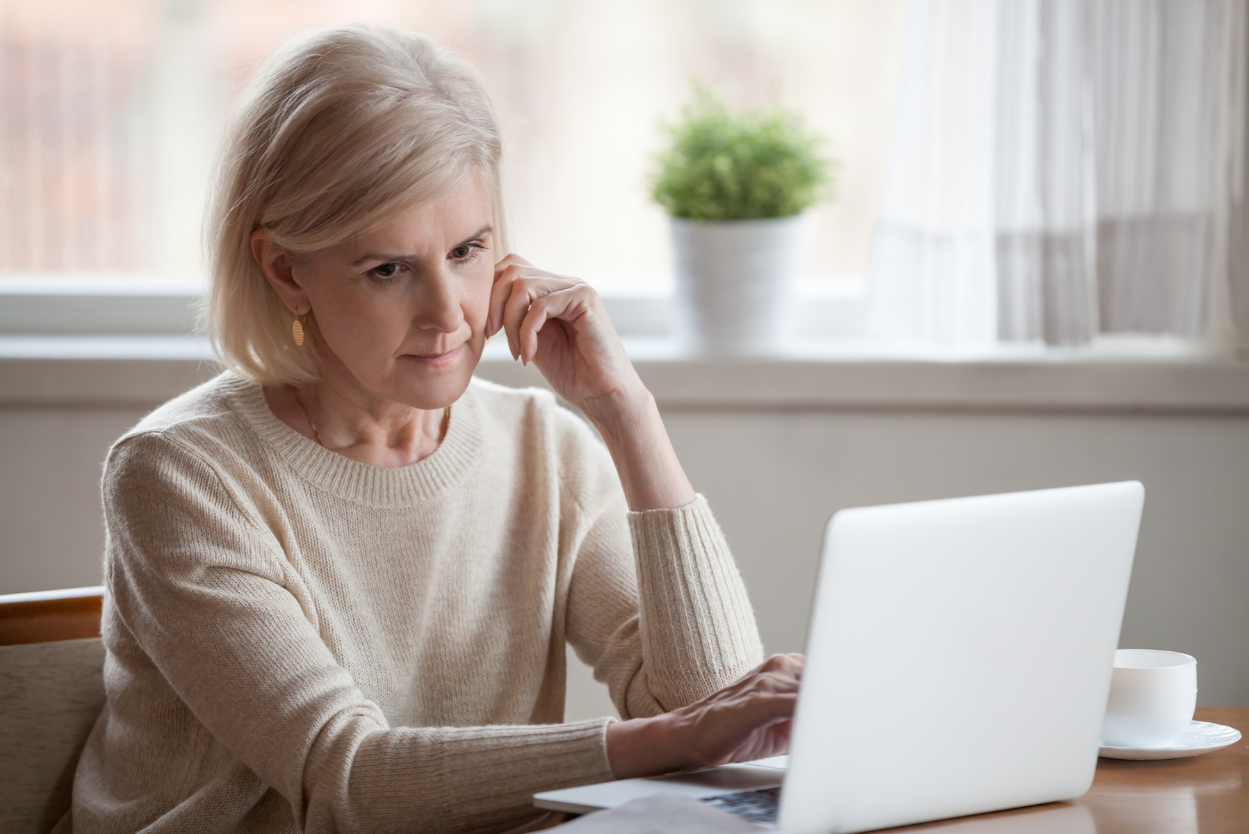 Worried woman looking at laptop