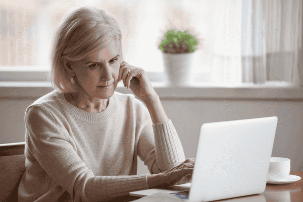 Worried woman looking at laptop