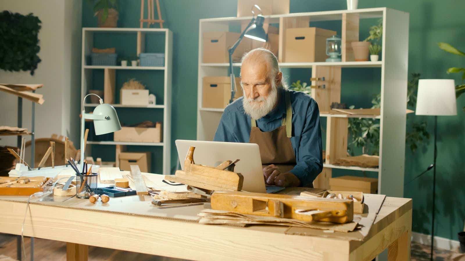 Tradesman working on his laptop in his studio.