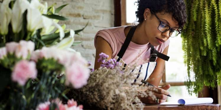 Woman in florist writing notes.