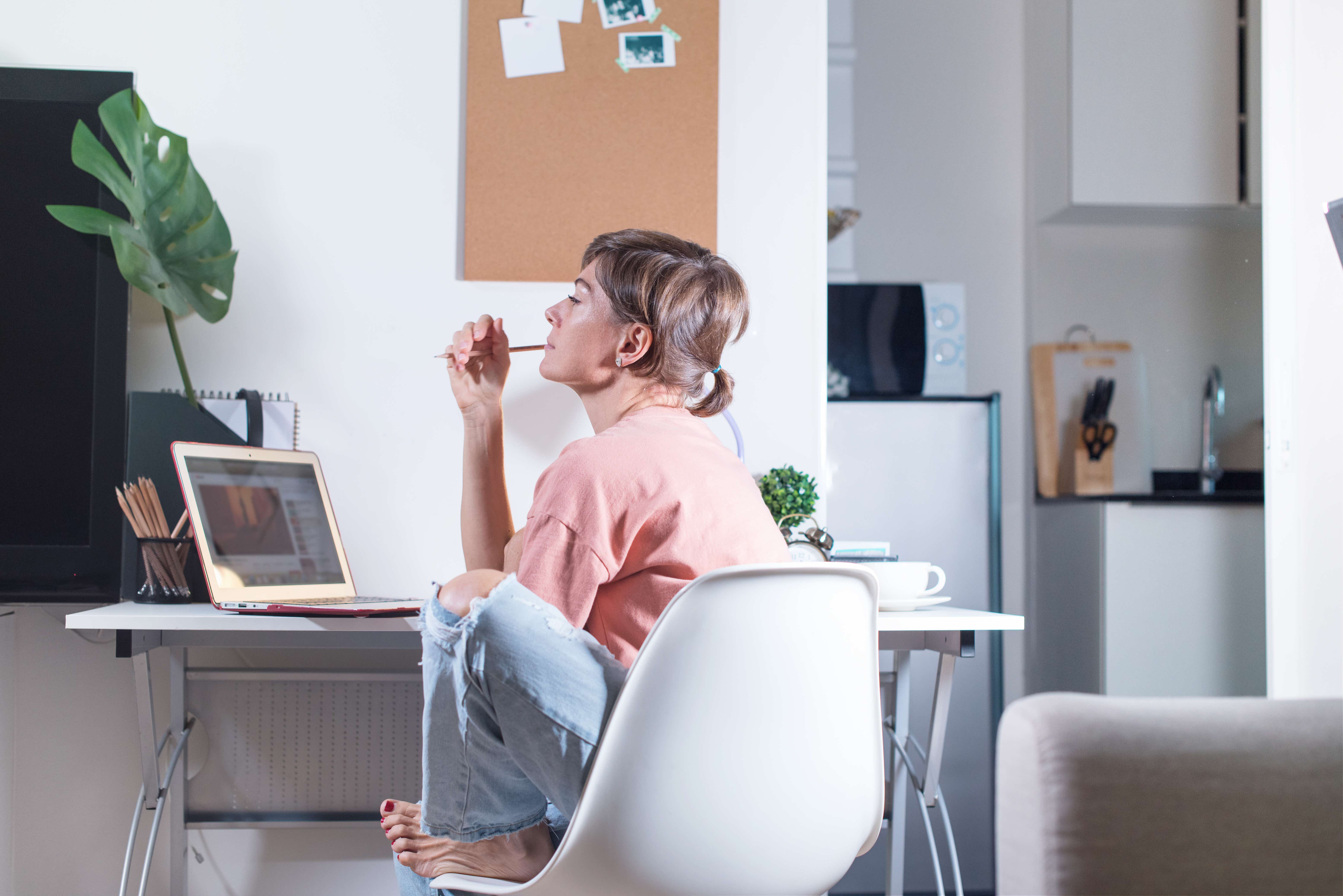 Woman sitting and thinking near table at home. Businesswoman working online during the quarantine. Self isolation. Networking. Online education. Coronavirus. Crisis. Researching. Debt.