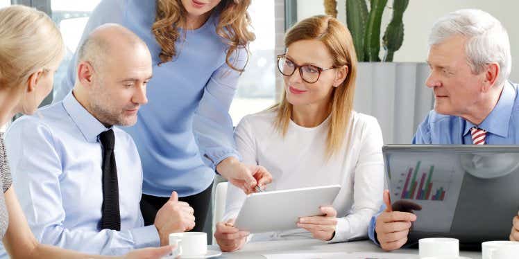 stockbrokers at a desk in an office meeting