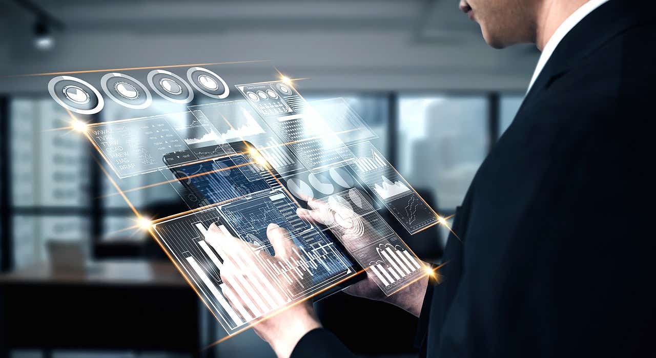 A man holds up a futuristic screen from the palm of his hands