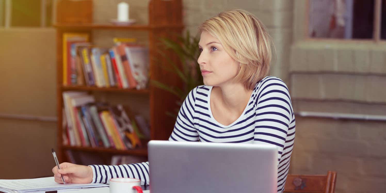 Women in striped shirt writing on paper pad