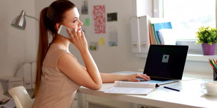 woman-on-phone-with-laptop-on-desk