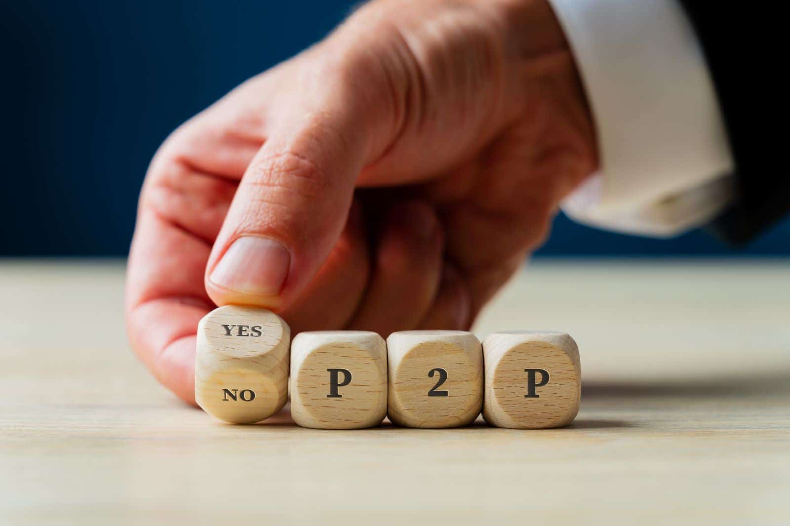 Three dice spelling out P2P. A fourth dice is held cocked between Yes and No. 