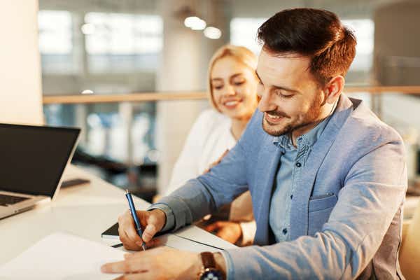 Man with woman signing documents.