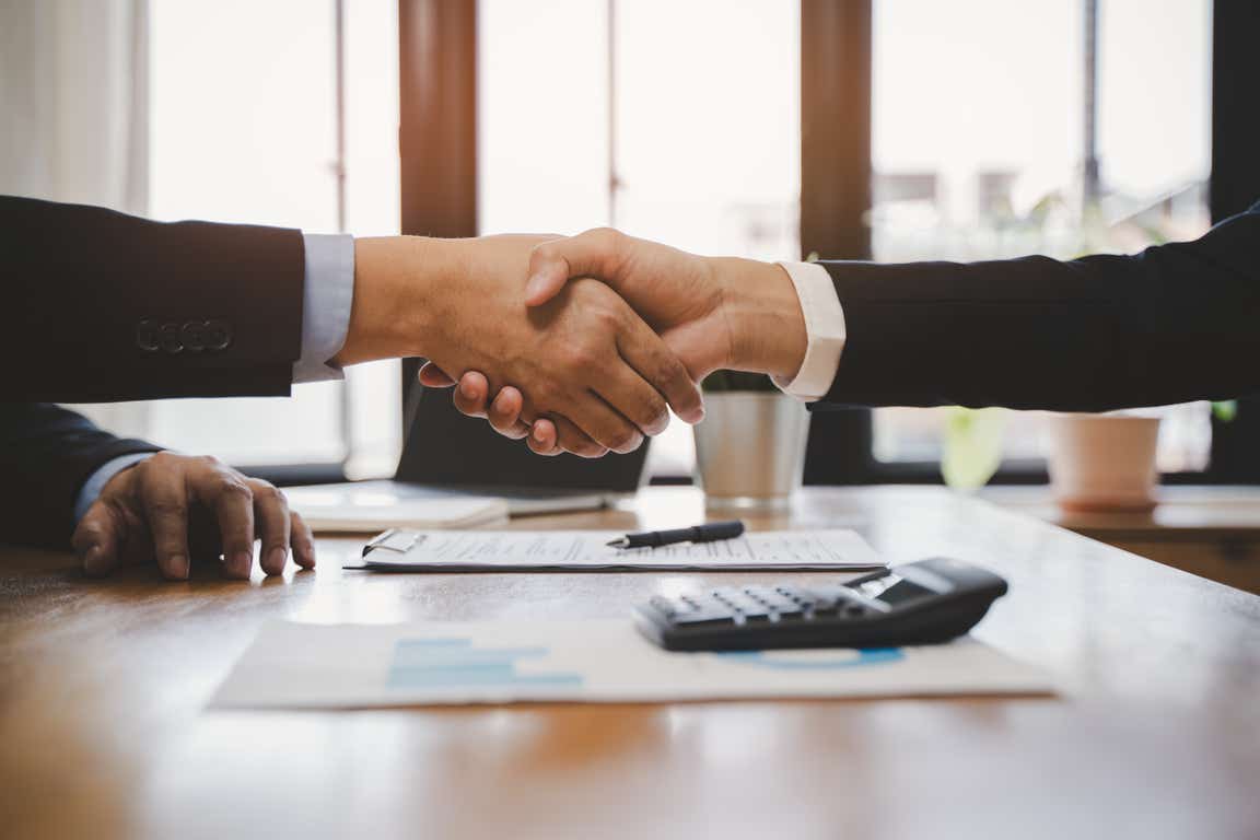 Two hands shaking over a contract