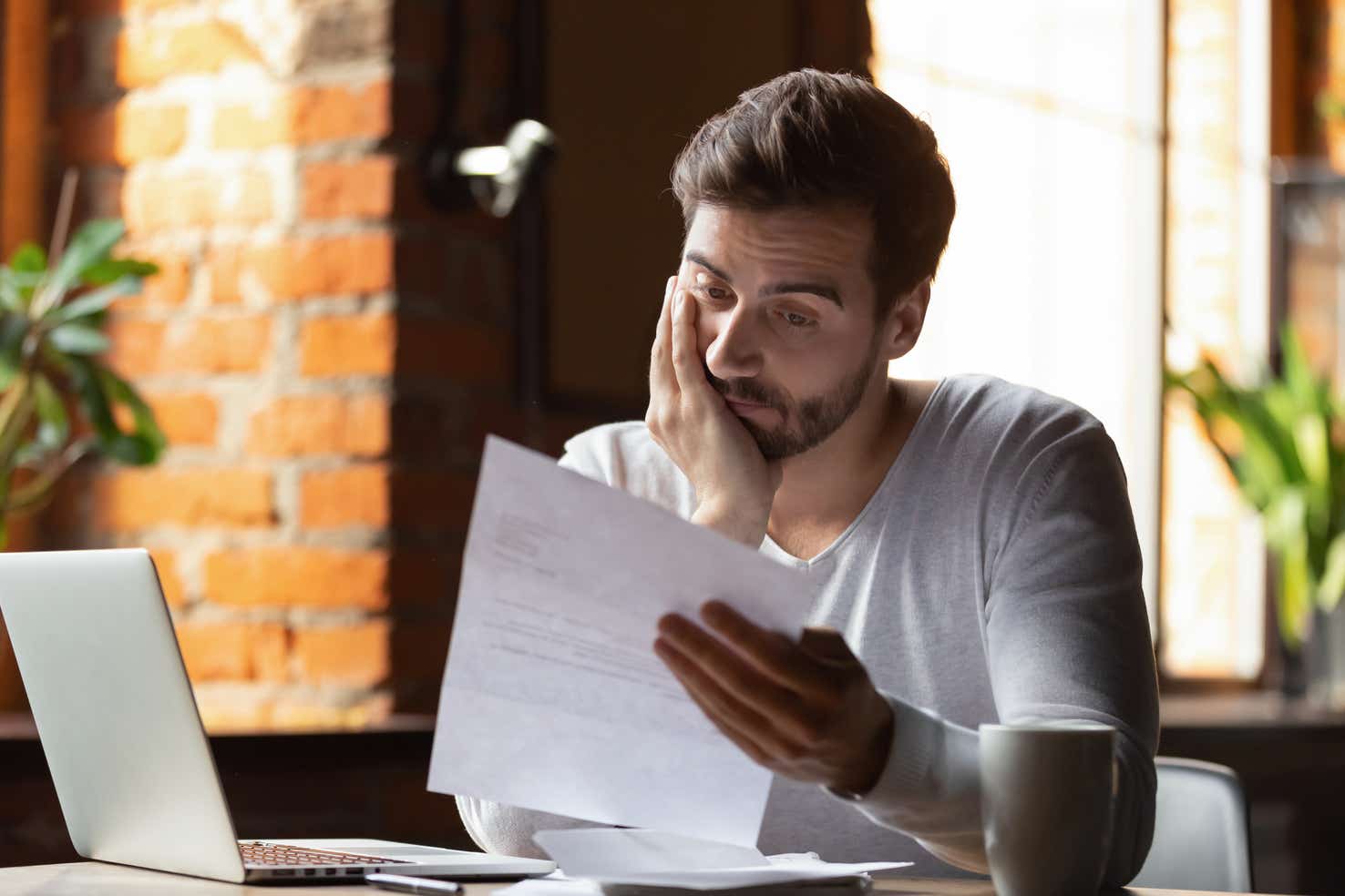 Man looking at his card statement with regret