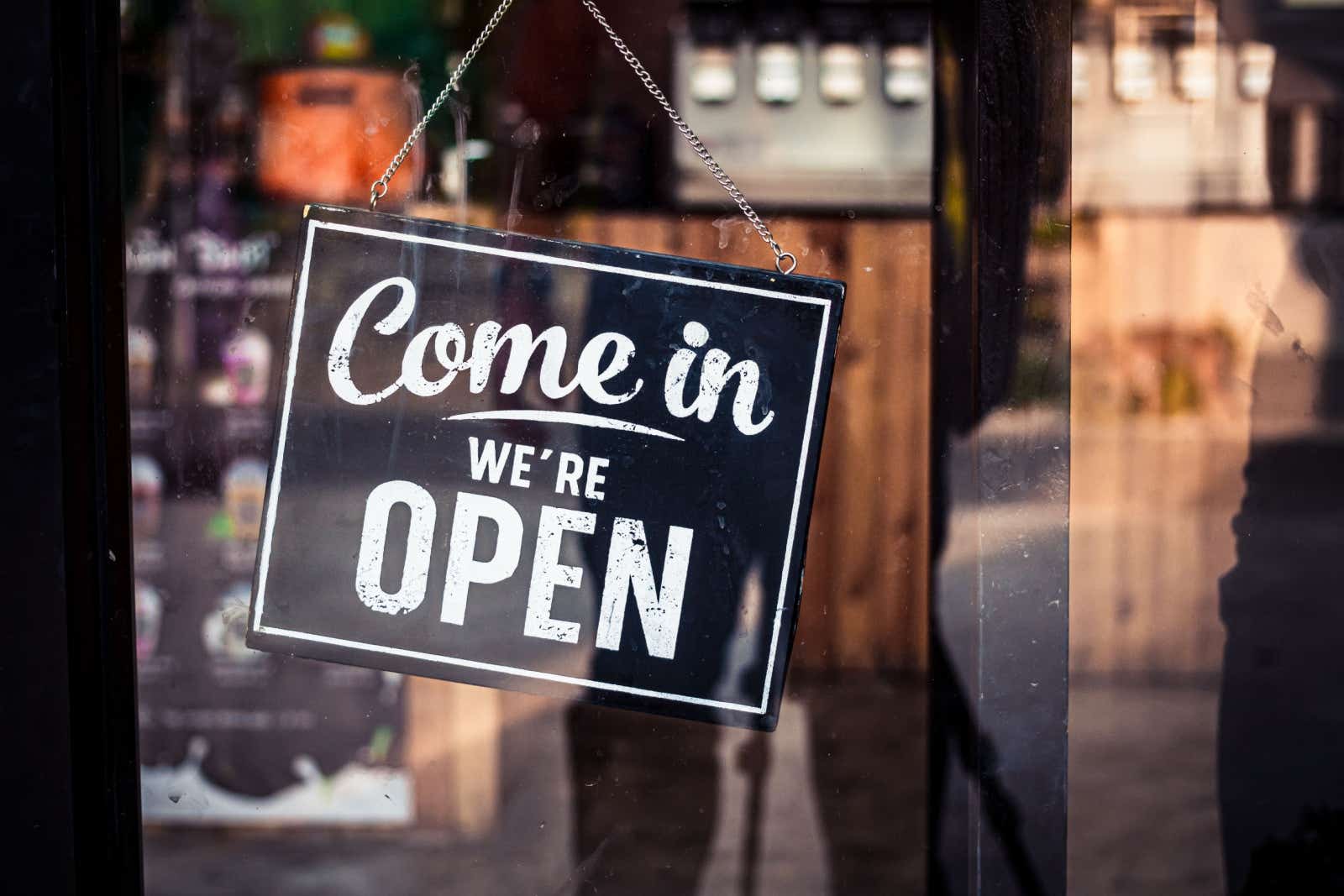 Sign in a shop window saying "Come in - we're open".