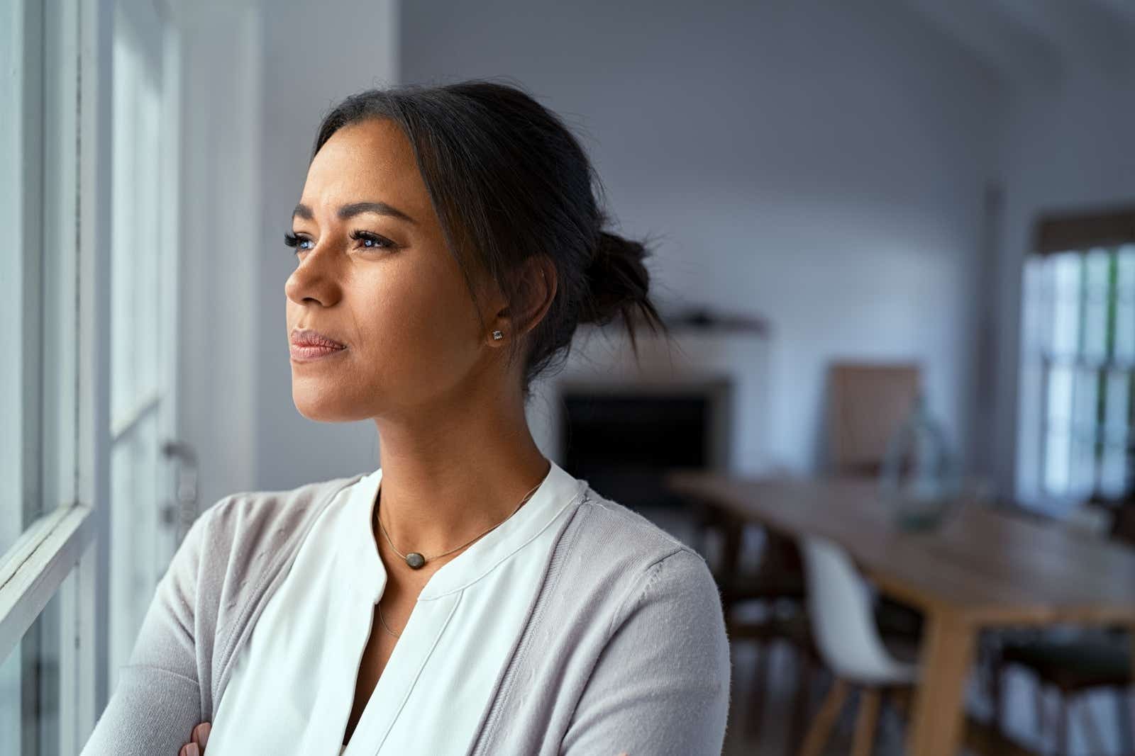 Pensive businesswoman looks out of a window