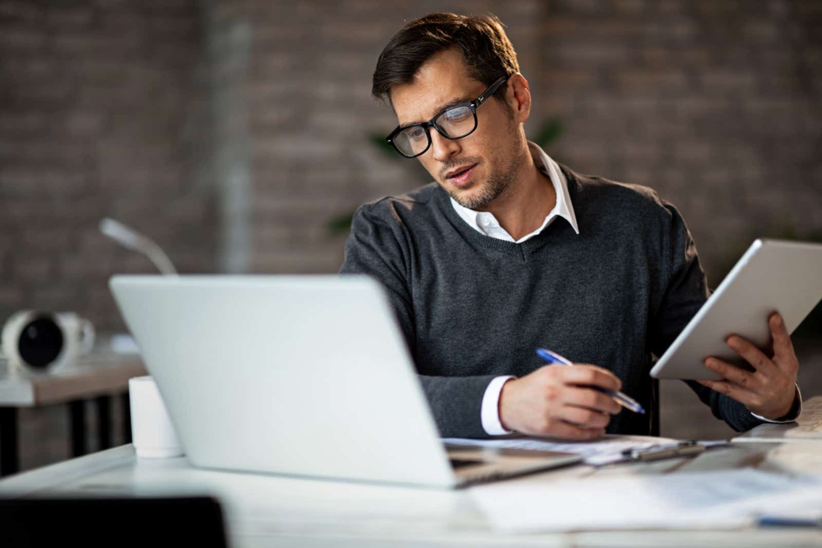 Businessman on laptop and tablet.