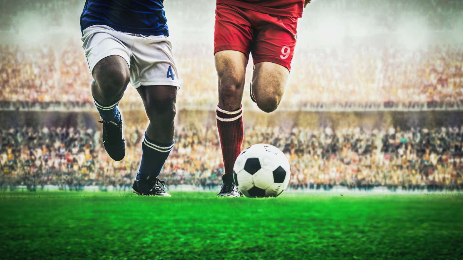 Footballers playing an a packed stadium