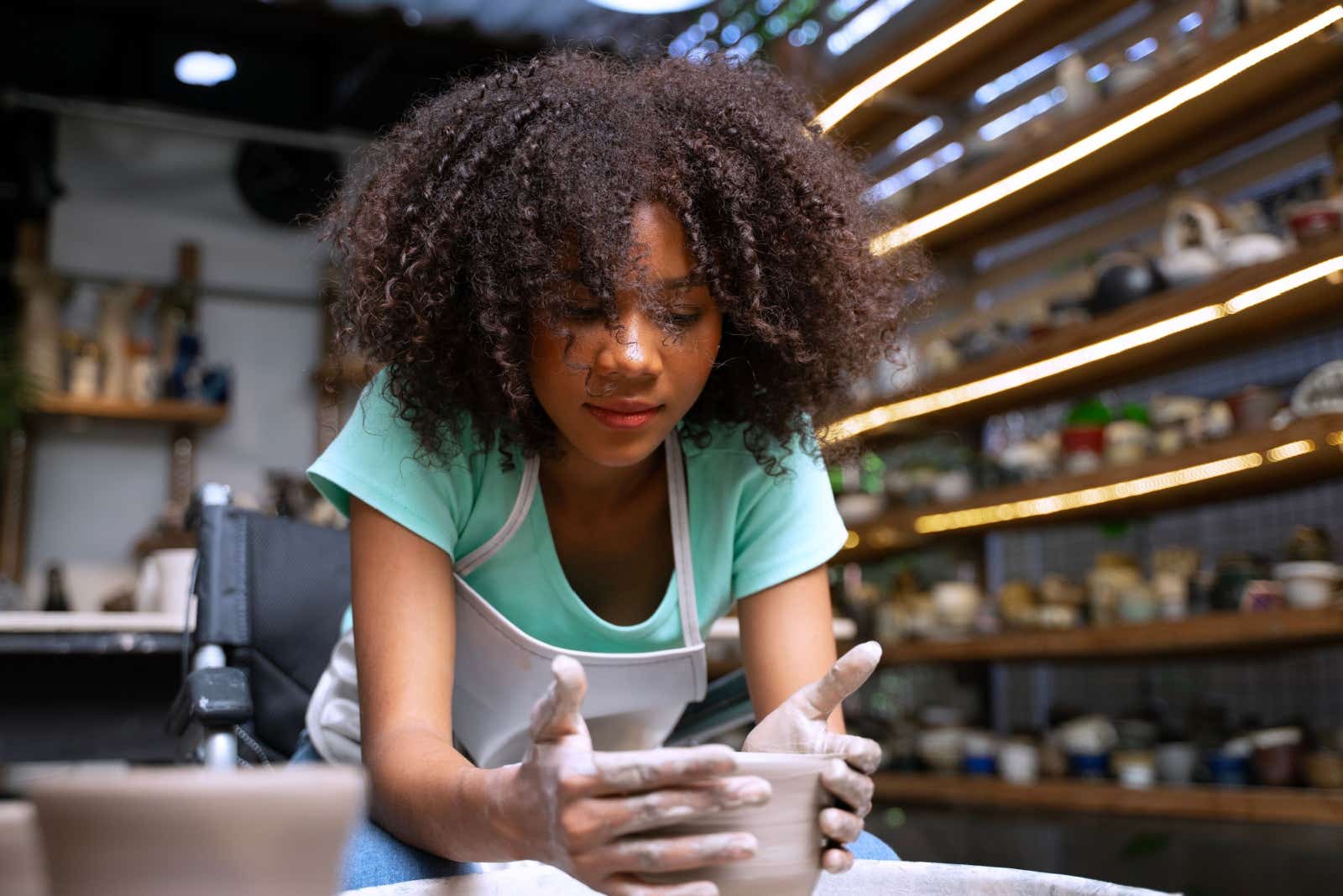 Woman working on a potter's wheel in her workshop.