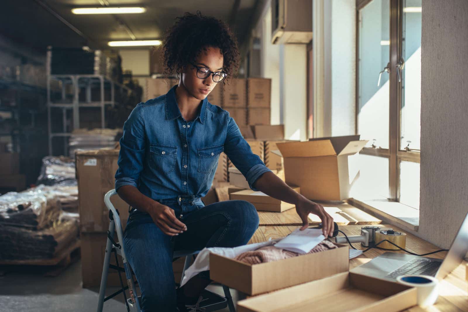 Businesswoman packaging up products for delivery to her client.