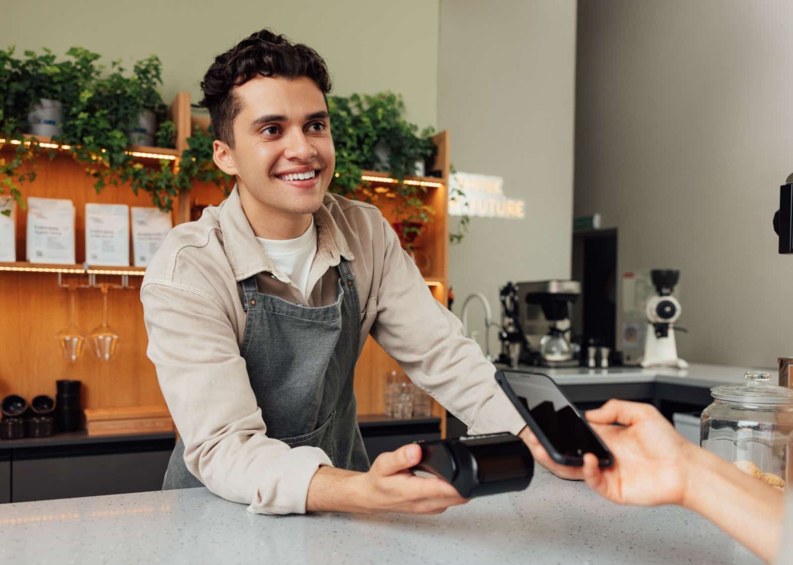 Man holds out card payment machine.