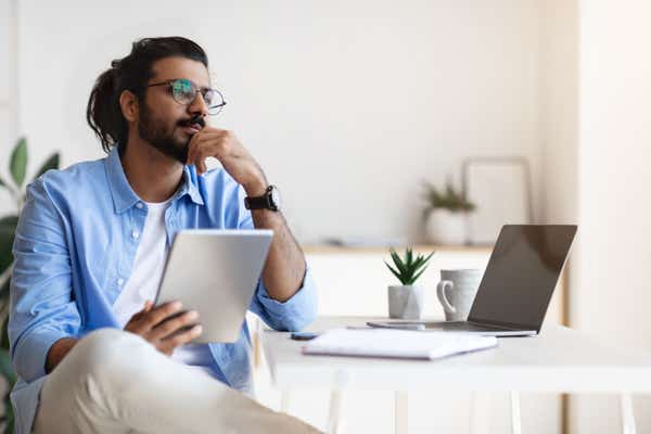 Laid-back businessman considering his options in minimalist office