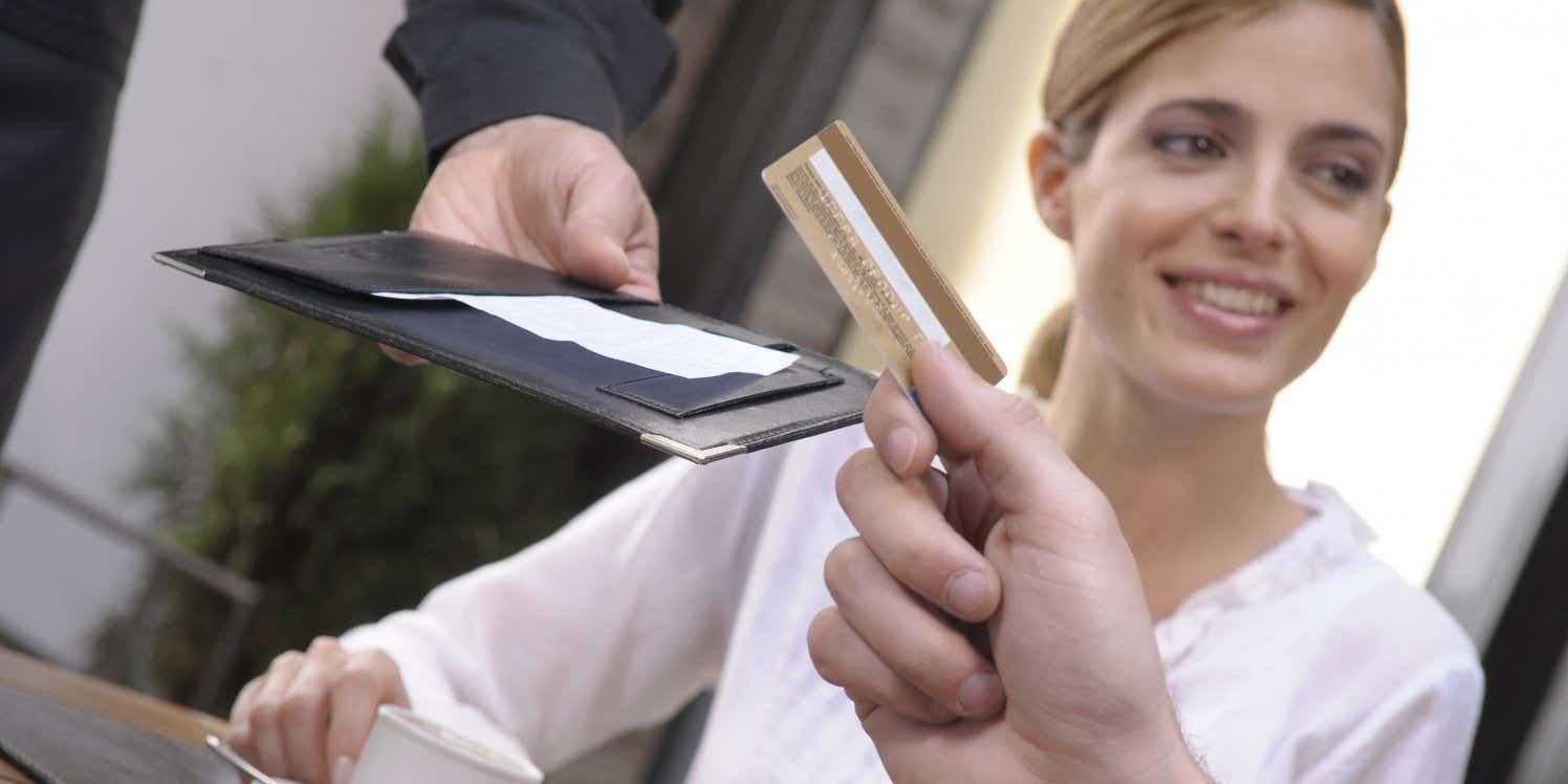 Couple paying bill in a restaurant with card. 