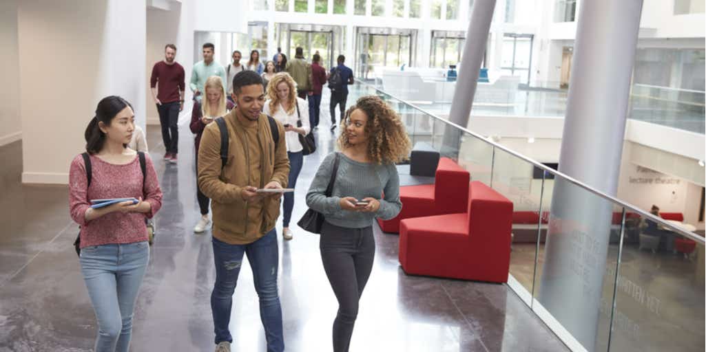 Students walk and talk using mobile devices in university