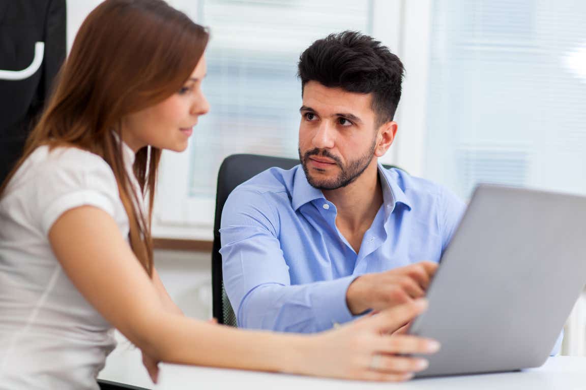 couple with laptop but looking concerned by what they can see