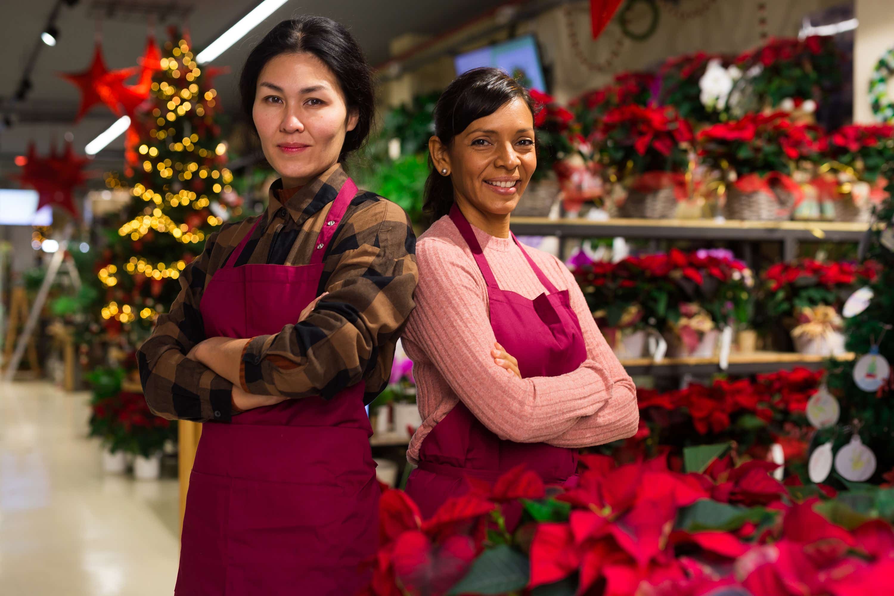 Two female business owners look on with confidence in a festive environment 