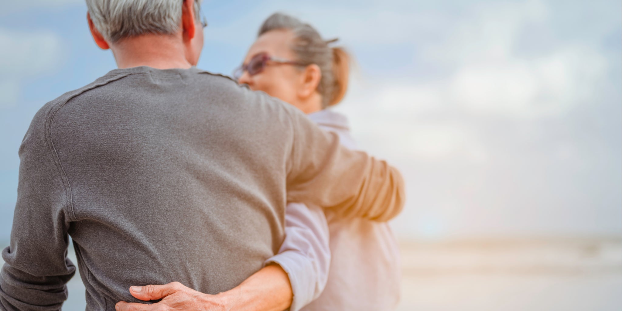Older couple, walking on a beach