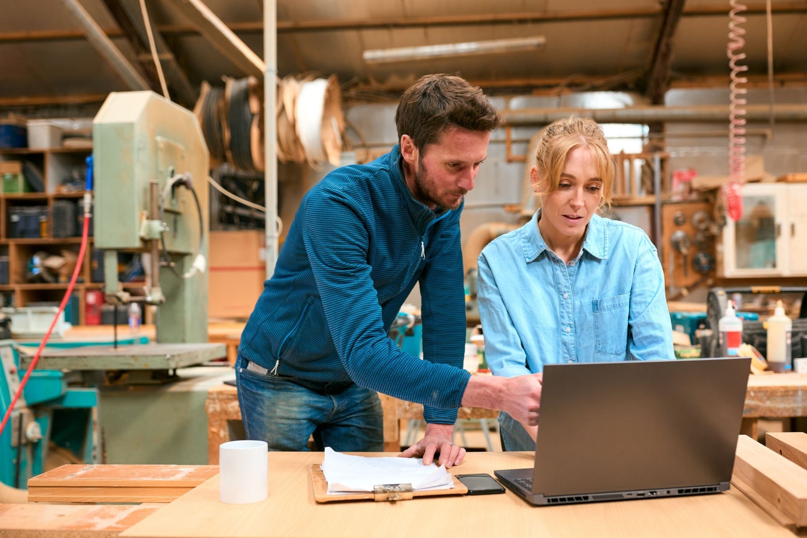 Two people in a workshop looking at a laptop