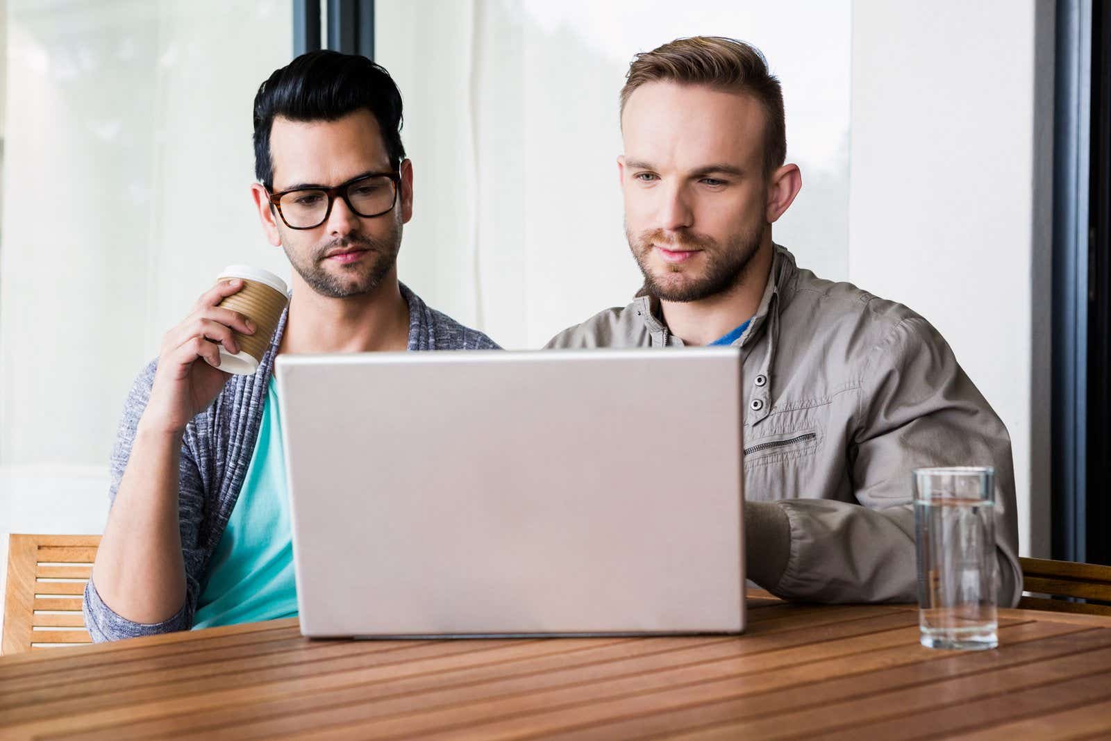 Same-sex couple looking at laptop