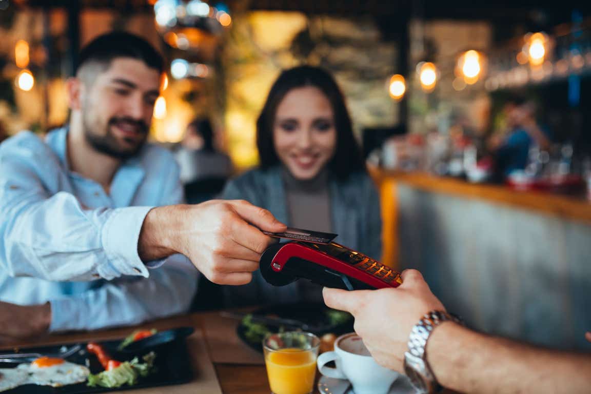 Couple paying for a meal in a restaurant with a card.