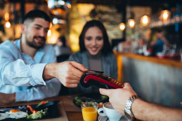 Couple paying for a meal in a restaurant with a card.