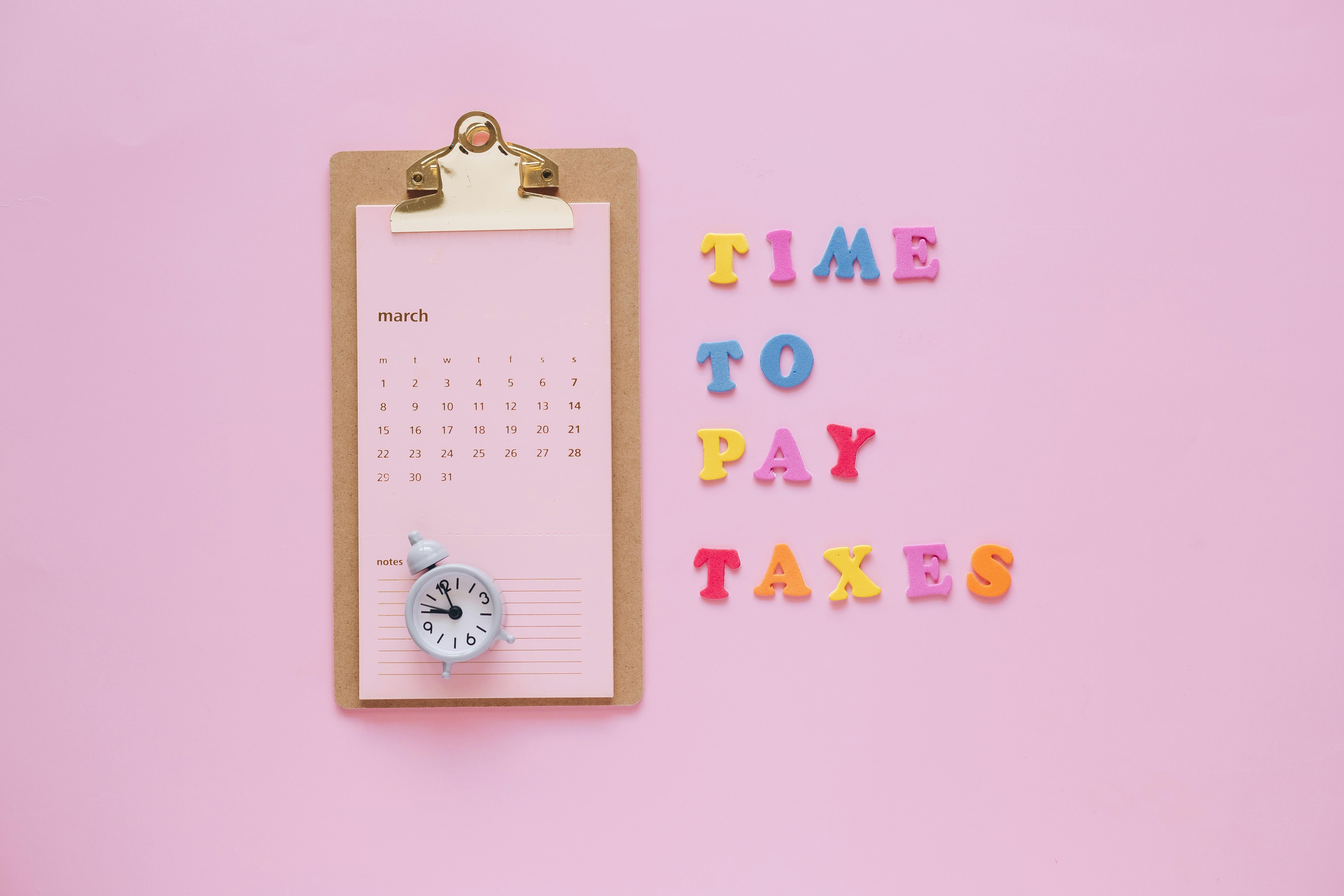 Note pad with a calendar and block letters "Time to pay" next to it