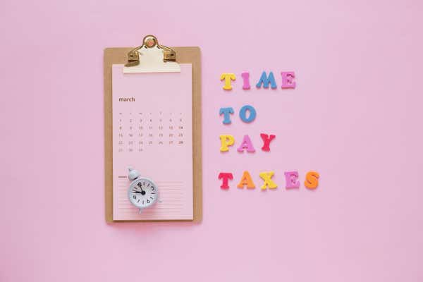 Note pad with a calendar and block letters "Time to pay" next to it