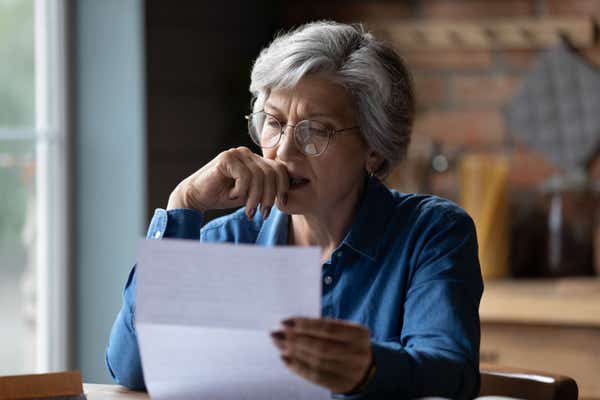 Business woman frowning as she reviews paperwork.