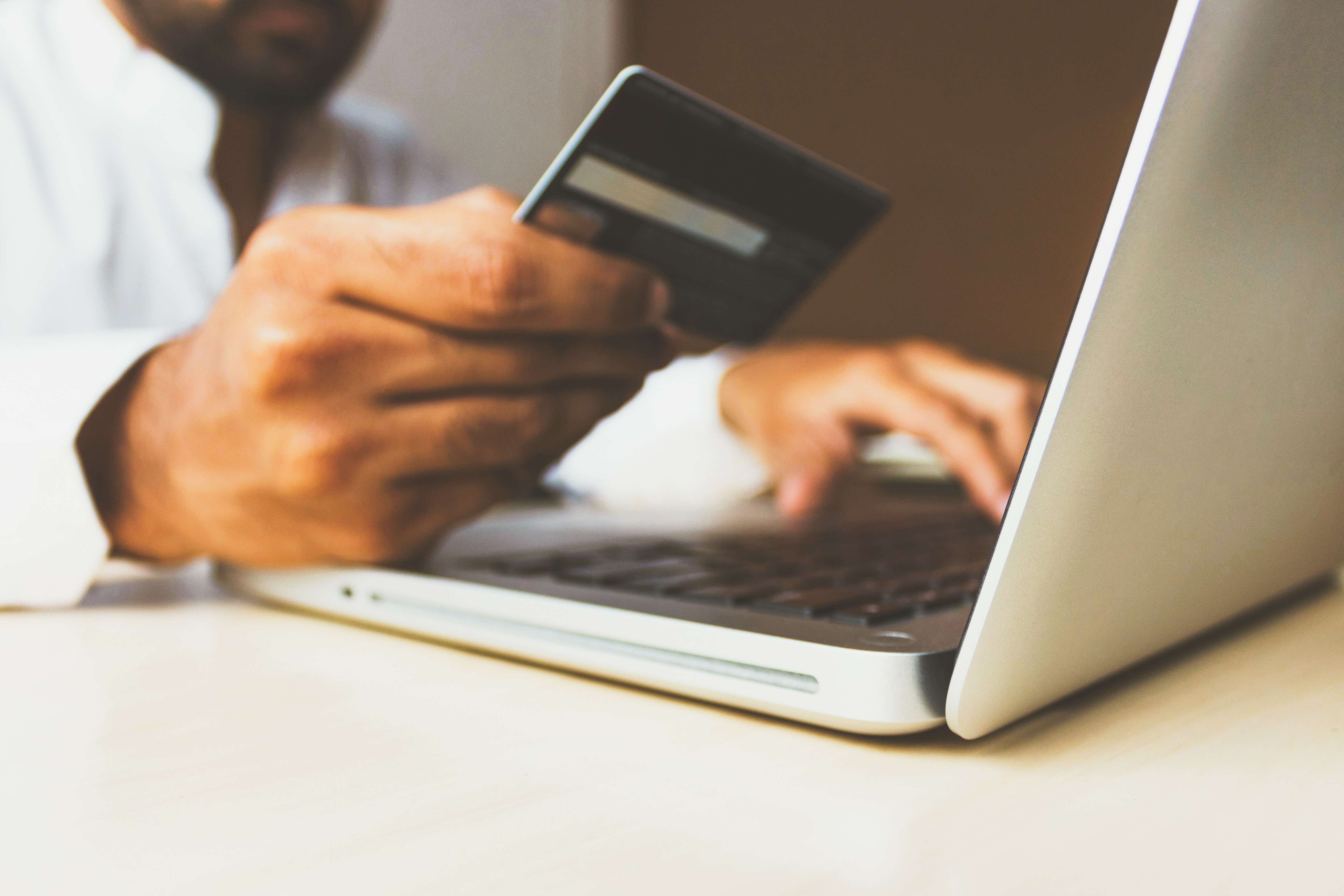 A picture of a man inputting his credit card details online.