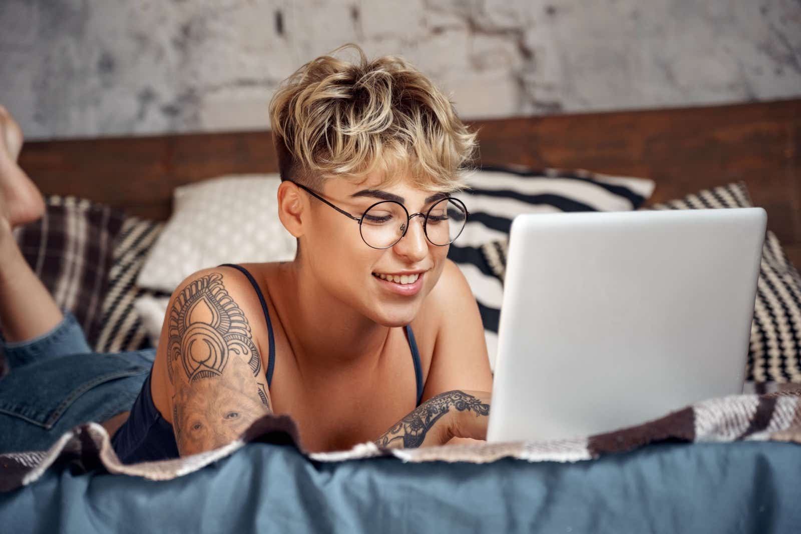 Woman lying on her front while working on a laptop.