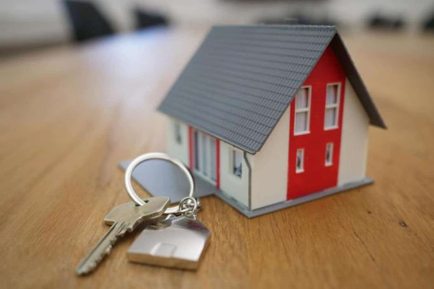 model house on a table next to a pair of keys