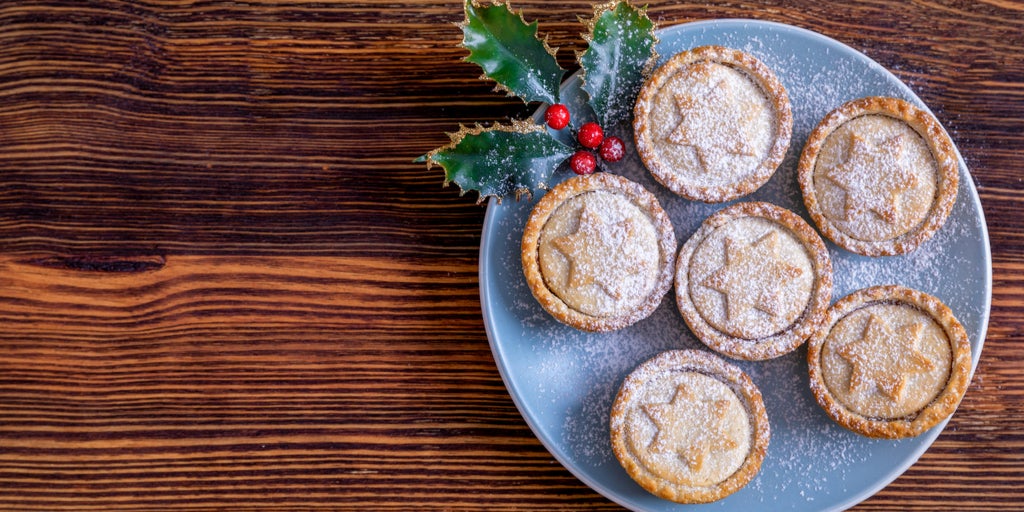 Wooden table with blue plate presenting mince pies
